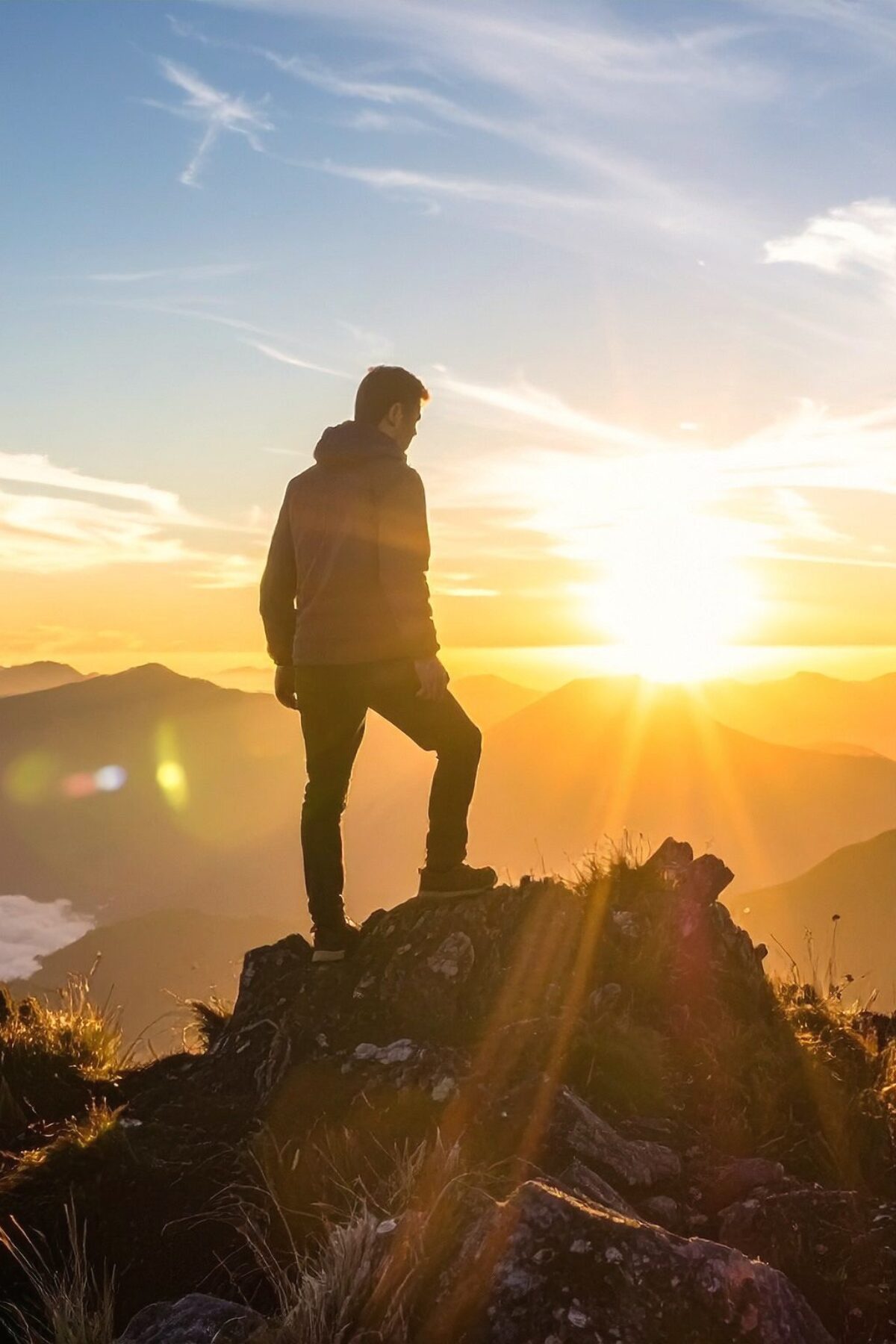Man standing on a mountaintop at sunrise, symbolizing clarity, confidence, and stepping into a new season of growth.